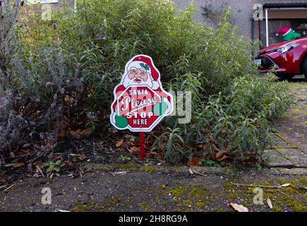 « Anta Please STOP HERE » affiche de Noël dans un jardin devant une maison à Surrey en décembre Banque D'Images