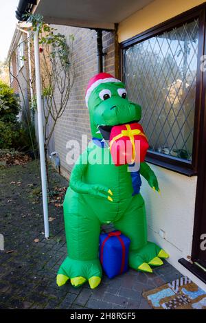 Grand dinosaure de fête en plastique de fantaisie vert à l'extérieur d'une maison à Surrey en décembre Banque D'Images