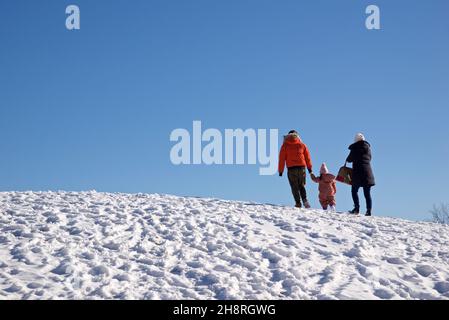 Famille heureuse en plein air - Père, mère et enfant s'amusent sur la neige randonnée d'hiver dans la nature. Banque D'Images