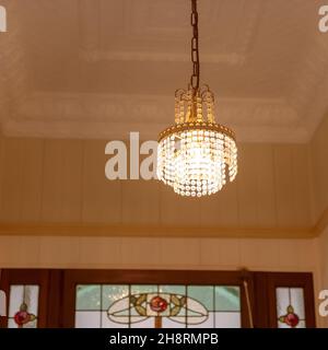 Chandelier Chrystal suspendu au plafond en plâtres avec vitraux ci-dessous à la maison familiale pionnière - amélioration du grain pour reproduire le TH Banque D'Images