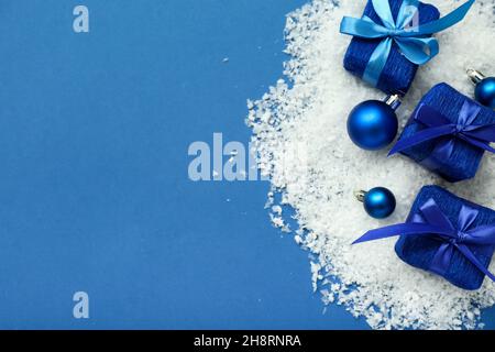 Cadeaux de Noël, décorations et neige sur fond bleu Banque D'Images