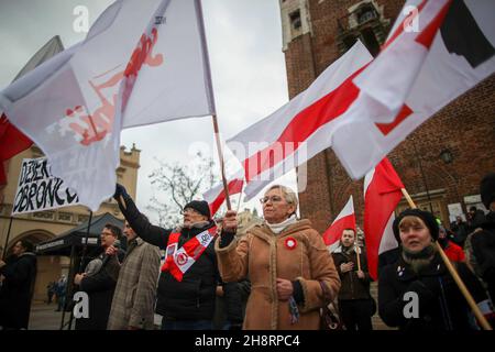 Cracovie, Pologne.20 novembre 2021.Les manifestants ont des drapeaux polonais pendant la manifestation.au début de l'année, la Pologne a imposé un état d'urgence à la frontière avec le Bélarus, car depuis un certain temps des étrangers, y compris des citoyens d'Irak, d'Afghanistan, de Syrie et du Yémen ainsi que des pays africains, ont atteint la Pologne à divers endroits de sa frontière avec le Bélarus.On refuse aux gens de chercher refuge et de traverser la frontière, ce qui a entraîné la mort, y compris des enfants.La situation à la frontière biélorusse-polonaise a polarisé les Polonais, certains s'opposant au traitement des réfugiés qui se sont rassemblés sur le groun Banque D'Images