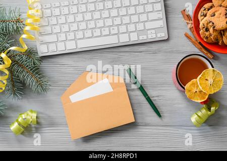 Composition avec enveloppe, carte, tasse de thé et clavier sur fond de bois gris Banque D'Images