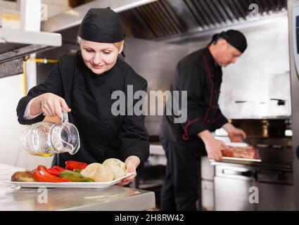 Plat d'assaisonnement à l'huile pour chef féminin Banque D'Images