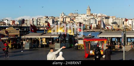 Istanbul, Turquie - 01 janvier 2021 : les gens se reposent et socialisent sur la place près du pont de Galata, des boutiques et de la destination historique d'Istanbul Banque D'Images