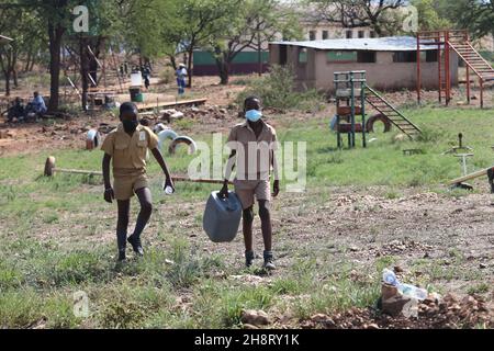 Gwanda, province de Matabeleland-Sud du Zimbabwe.3 novembre 2021.Les élèves sont en route pour aller chercher de l'eau dans une école primaire de Gwanda, province du Sud de Matabeleland, au Zimbabwe, le 3 novembre 2021.Les projets de forage de trous de sonde financés par la Chine fournissent une bouée de sauvetage aux communautés pauvres en eau en Afrique où l'accès facile à l'eau potable reste un défi pour certaines populations du continent.POUR ALLER AVEC 'Feature: Les projets d'eau soutenus par la Chine apportent de la joie aux communautés en Afrique' Credit: Chen Yaqin/Xinhua/Alamy Live News Banque D'Images