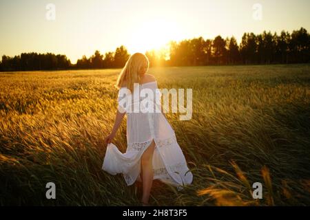 grossesse, personnes, repos, concept d'attente, femme enceinte heureuse se tient dans le champ et touche la nature du ventre Banque D'Images