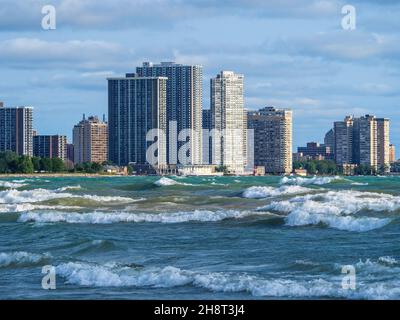 Surfez en hauteur sur la plage de Montrose à Chicago avec des immeubles d'appartements dans le quartier Edgewater en arrière-plan. Banque D'Images