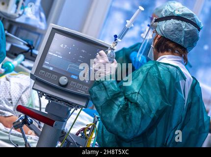 Rostock, Allemagne.30 novembre 2021.Une infirmière de soins intensifs s'occupe d'un patient dans l'une des salles de traitement de l'unité de soins intensifs du centre médical universitaire Rostock.Compte tenu de la montée en flèche du nombre de patients infectés par le Corona et de l'utilisation élevée des unités de soins intensifs, le Centre médical de l'Université a formé un Comité consultatif d'éthique Covid.Les patients de Saxe sont également traités dans la clinique.Credit: Jens Büttner/dpa-Zentralbild/dpa/Alay Live News Banque D'Images