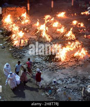 New Delhi, Inde.02e décembre 2021.Les travailleurs et les membres de la famille apportent un corps de crémation près de plusieurs pyres funéraires des victimes de COVID-19 brûlent sur un terrain qui a été converti en crématorium à New Delhi, en Inde, le samedi 1er mai 2021.Photo par Abhishek/UPI crédit: UPI/Alay Live News Banque D'Images