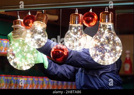 Cologne, Allemagne.02e décembre 2021.Une femme nettoie les lampes dans une cabine au marché de Noël en face de la cathédrale.Credit: Henning Kaiser/dpa/Alay Live News Banque D'Images