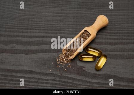 Graines de chia naturel bio et pelle en bois gros plan sur fond en bois ou table Banque D'Images