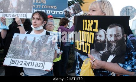 Les militants de gauche israéliens et les partisans du mouvement Peace Now présentent des panneaux montrant des photos de soldats israéliens avec des écrits qui se lisent sur « c'est à quoi ressemble l'occupation » et un panneau avec l'image du meurtrier de masse Baruch Goldstein lors d'une manifestation contre la visite du président israélien Isaac Herzog à l' La mosquée d'Ibrahimi, que les Juifs désignent comme la grotte de Machpelah, à l'entrée de la colonie israélienne de Kiryat Arba près de la ville palestinienne d'Hébron en Cisjordanie, Israël. Banque D'Images