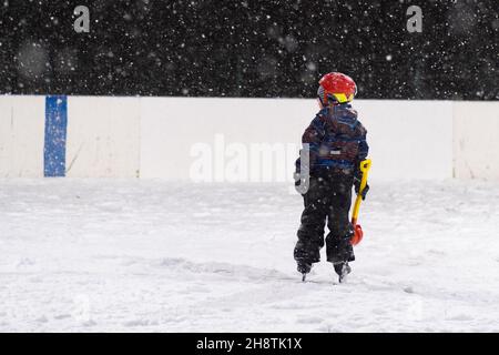 24.11.2021. Fortes chutes de neige à Moscou.Personnes avec enfants sur une patinoire près du parc Tsaritsyno.Photo de haute qualité.De fortes chutes de neige ont enseveli Moscou dans de gigantesques amas de neige, perturbant les transports, retardant les vols et rendant difficile la circulation des piétons qui bravent les vents forts et les températures Banque D'Images