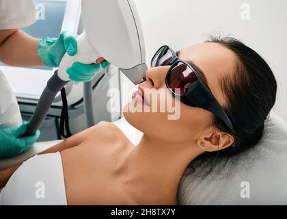 Belle femme ayant l'épilation au laser et l'épilation au laser de la zone des lèvres sur son visage au salon de cosmétologie Banque D'Images