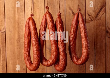 saucisses fermentées liées anneaux suspendus sur corde. Banque D'Images