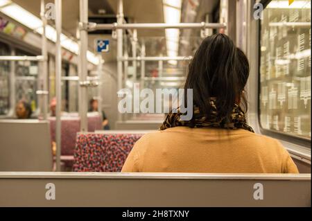 Berlin, Allemagne.Une jeune femme adulte se déplaçant dans le métro des villes tout en étant assise dans un U-Bahn presque abandonné. Banque D'Images