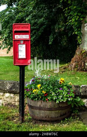 Boîte postale rouge emblématique anglaise dans le joli village Banque D'Images