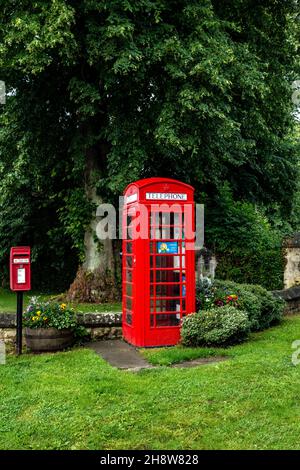 Téléphone rouge emblématique anglais dans joli village maintenant une banque de semences Banque D'Images