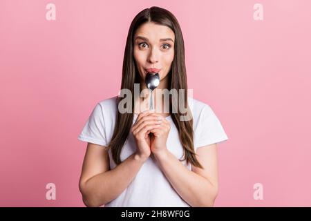 Photo portrait jeune femme léchant cuillère faim isolé pastel couleur rose fond Banque D'Images