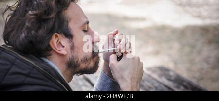 Homme éclairant une cigarette conjointe de marihuana ou de haschisch.Vue de détail en gros plan.Les jeunes fument du cannabis thc herbe.Concept de scène de la vie réelle Banque D'Images