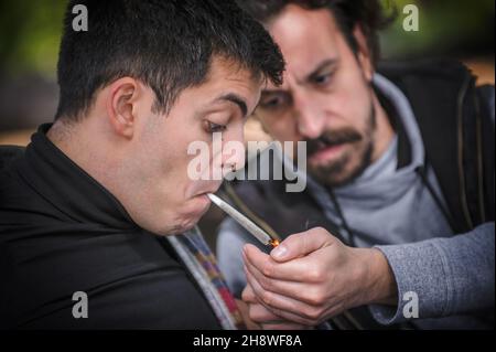 Homme éclairant une cigarette conjointe de marihuana ou de haschisch.Vue de détail en gros plan.Les jeunes fument du cannabis thc herbe.Concept de scène de la vie réelle Banque D'Images