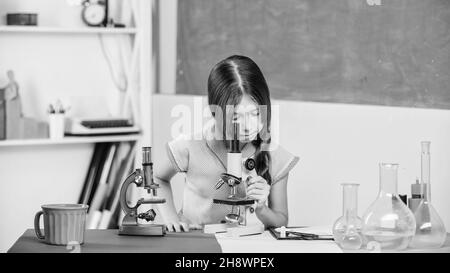 Tubes d'essai de classe biologie pour filles.Leçon de science.Laboratoire scolaire.Petite fille avec microscope.Expérience scientifique.Leçon fascinante.Explorer Banque D'Images