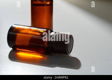 Flacons en verre ambré pour cosmétiques, médicaments naturels ou huiles essentielles sur fond gris Banque D'Images