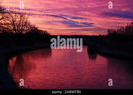 Le soleil brûlant rouge vient de se lever sur les eaux glacées et froides des canaux de Leeds et Liverpool, le matin d'automne près de Burscough Banque D'Images