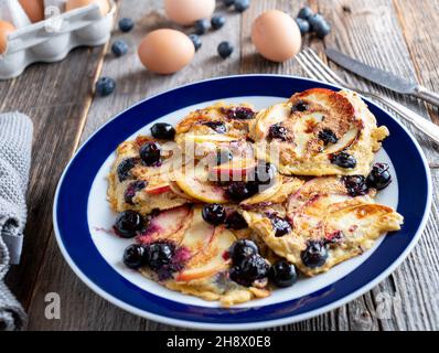 Petit déjeuner de remise en forme avec crêpes aux flocons d'avoine poêlées, pommes et myrtilles sur une assiette Banque D'Images