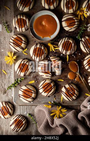 Vue de dessus pile de délicieux petits gâteaux fraîchement cuits avec de la bruine de caramel et de chocolat servi sur une table en bois dans la cuisine légère Banque D'Images