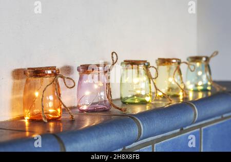 Lumières à DEL dans des verres de couleur sur un poêle en faïence Banque D'Images