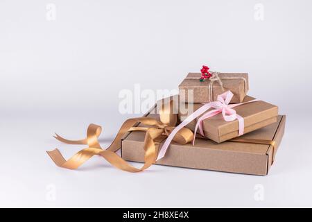 Arrière-plan des boîtes-cadeaux de Noël.Boîte cadeau emballée dans du papier Kraft avec ruban sur fond blanc. Banque D'Images