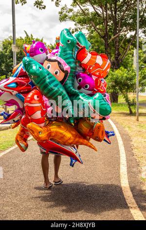 Goias, Brésil – 1er décembre 2021 : le vendeur de ballons dans un parc.Une personne tenant plusieurs ballons qui cachent son corps entier. Banque D'Images