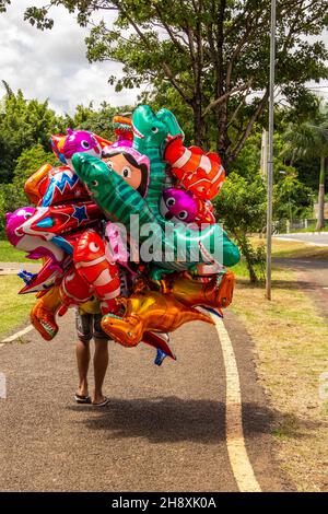 Goias, Brésil – 1er décembre 2021 : le vendeur de ballons dans un parc.Une personne tenant plusieurs ballons qui cachent son corps entier. Banque D'Images