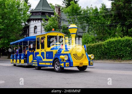 Sinaia, Roumanie - 3 juillet 2021 : train coloré pour les enfants dans une rue du centre de la ville, près des monts Bucegi (Muntii Bucegi) à Prahova Banque D'Images