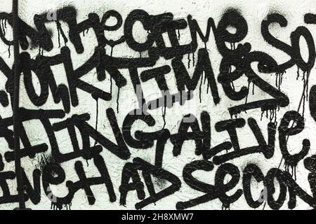 Graffiti noir et blanc dessinant à partir de mots aléatoires dans une belle police sur le mur comme décoration ou décoration Banque D'Images