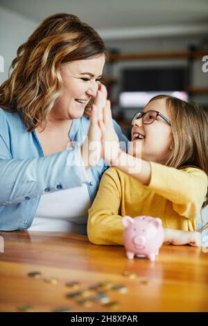 piggy banque mère fille argent épargne monnaie financer enfant famille heureux investissement Banque D'Images