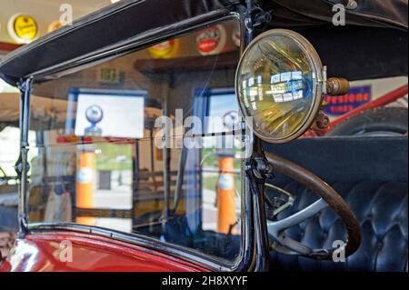 Un roadster ancien Oldsmobile des années 1920 à toit ouvert dans un garage de station-service