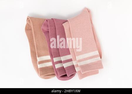 trois chaussettes en coton beige, rose et rouge isolées sur fond blanc, accessoires chauds, vue du dessus Banque D'Images