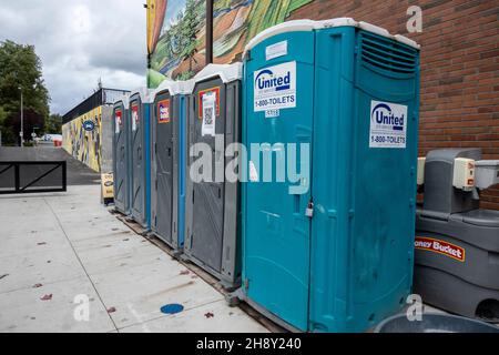 Woodinville, WA USA - vers septembre 2021: Vue sur la rue d'une ligne de port-a-potties dans le centre-ville, par une journée nuageux. Banque D'Images