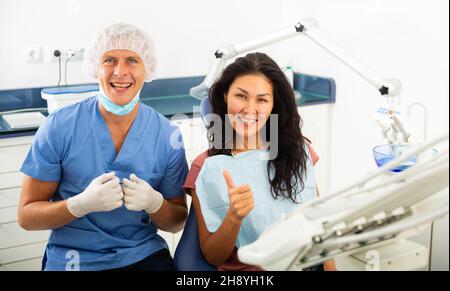 Portrait d'un dentiste souriant qualifié avec une patiente satisfaite Banque D'Images