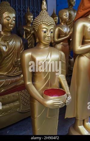 Statues de Bouddha dans une usine d'objets bouddhistes à Bamrung Muang Rd., Bangkok, Thaïlande, une statue tenant un bol d'almes utilisé par les moines bouddhistes Banque D'Images
