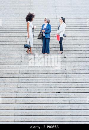 collègues parlant au milieu d'un escalier en granit Banque D'Images