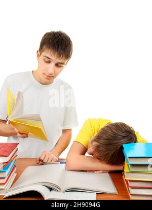 Frère aîné et petit frère ennuyé faisant le travail à domicile sur le fond blanc Banque D'Images