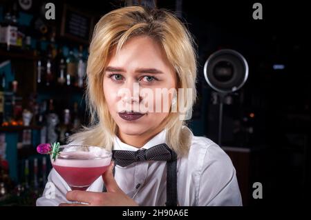 Un barman concocte un cocktail derrière le bar Banque D'Images