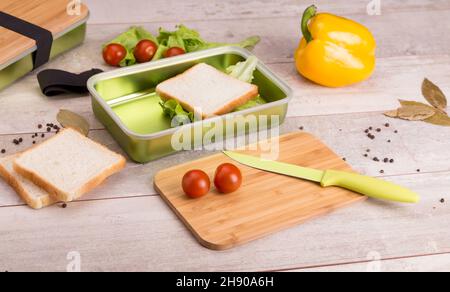 Sandwich avec fromage et jambon sur la planche à découper sur la table dans la cuisine lumineuse.Déjeuner.Sandwich avec de la laitue.Concept de saine alimentation Banque D'Images