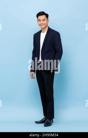 Portrait complet de jeunes hommes d'affaires millénaires d'Asie du Sud-est, beaux et beaux, regardant l'appareil photo sur fond de studio bleu clair Banque D'Images