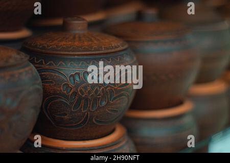 Une rangée de pots d'argile faits à la main avec un fond défoqué.Plat de cuisson en céramique au four Banque D'Images