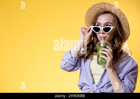 Rafraîchissements en été. Boisson froide. Bonne femme en lunettes de soleil tenant le verre en plastique de mojito. Boisson non alcoolisée. Limonade détox. Banque D'Images